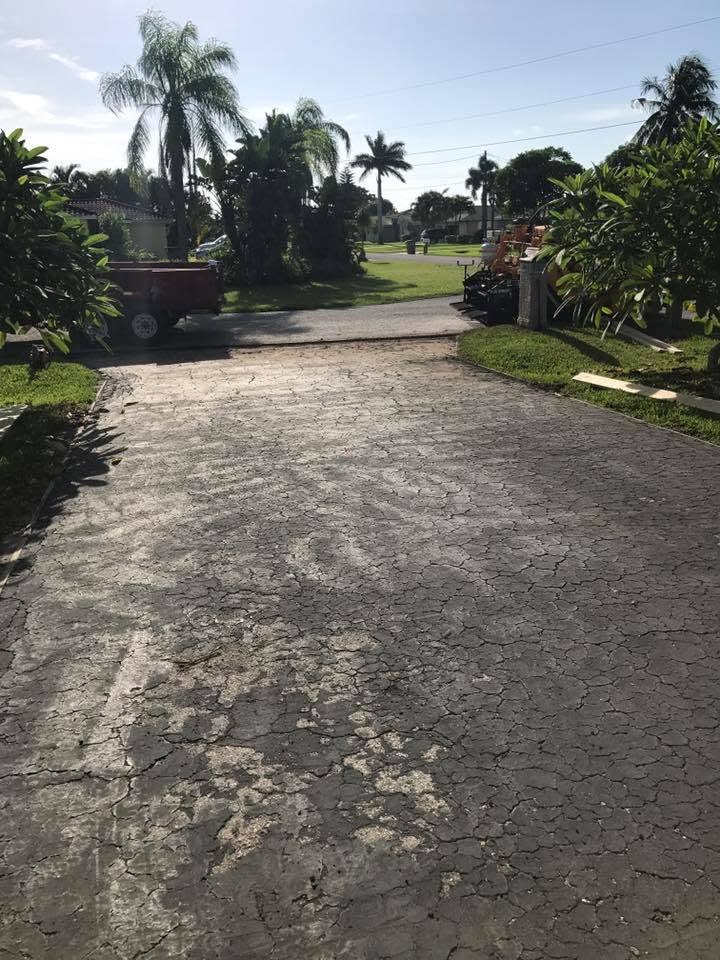 Cracked, faded asphalt driveway before sealcoating in Cape Coral, Florida
