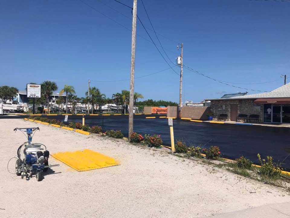 Sealcoated marina restaurant lot with striping machine staged nearby
