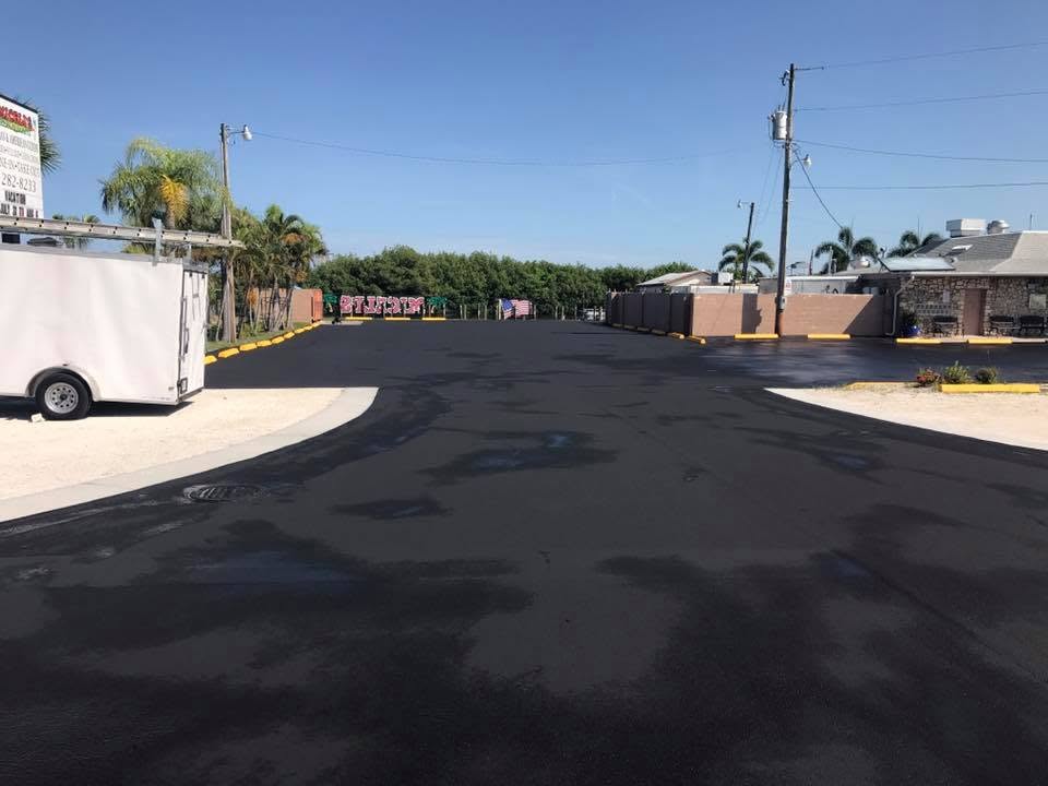 Freshly sealcoated restaurant parking lot with yellow curbing in Cape Coral, Florida
