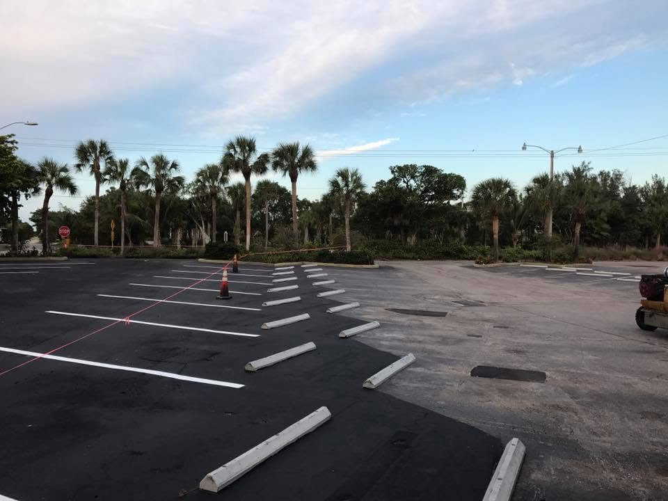 Side by side contrast of freshly sealcoated asphalt next to faded pavement