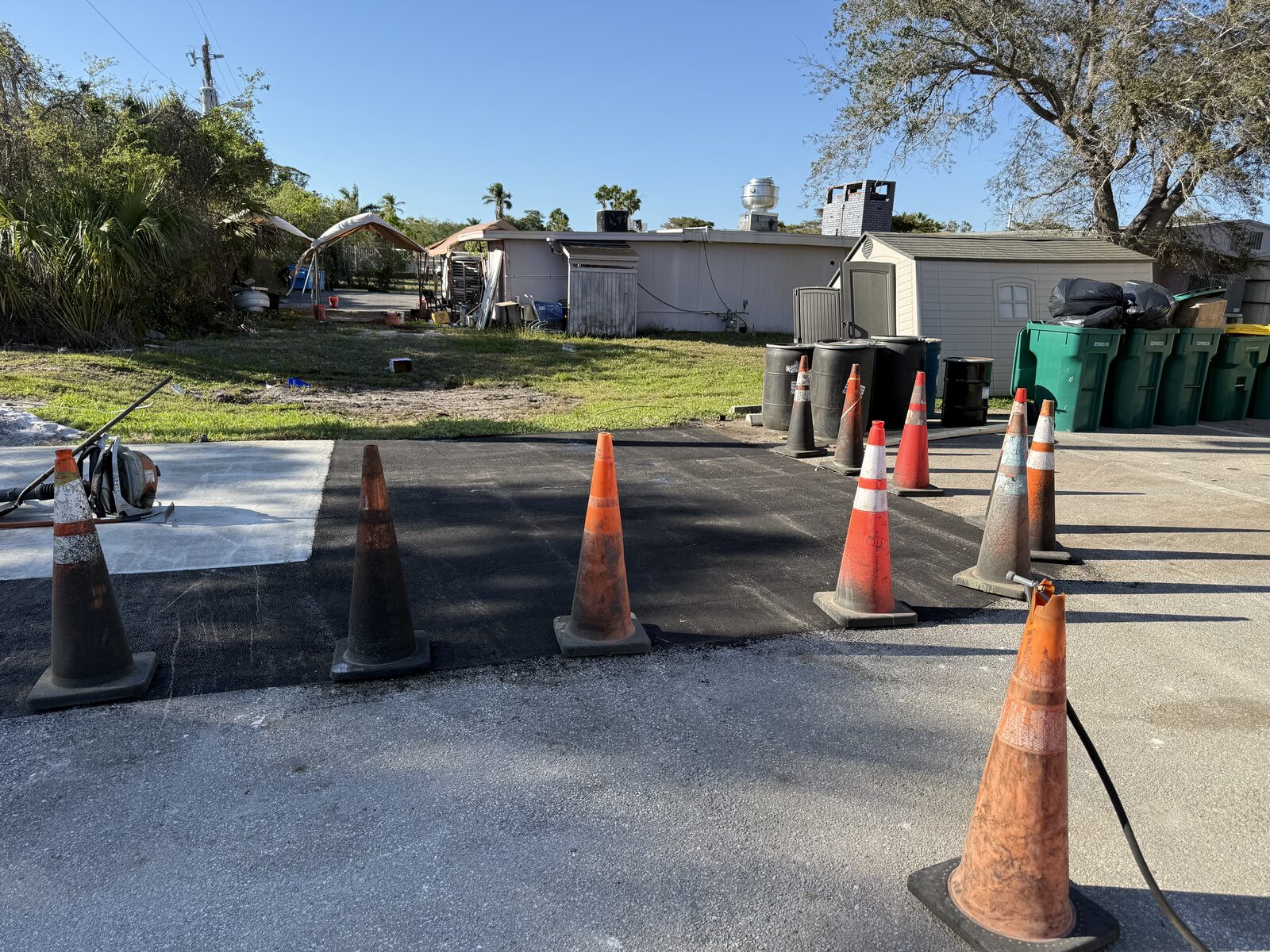 Asphalt repair and patching in progress with traffic cones on site